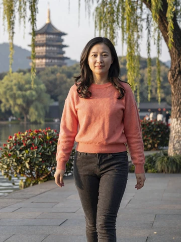 Chinese woman walking near West Lake in Hangzhou park at golden hour, representing modern Chinese dating experience on iDatingZone