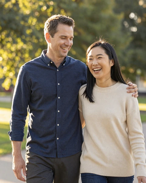 Happy intercultural couple walking together in a park, representing the cross-cultural connections built through Asian iDatingZone