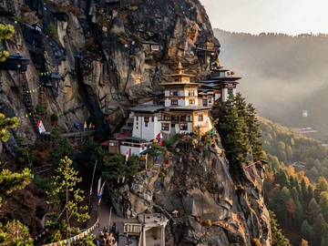 Tiger's Nest Monastery perched on cliff face in Paro valley Bhutan surrounded by pine forests, iconic symbol of Bhutanese Buddhist heritage and spiritual values