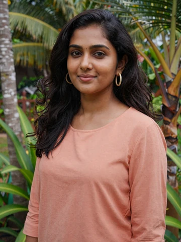 Sri Lankan woman in casual peach blouse smiling in tropical garden in Colombo, representing genuine Ceylon dating profiles
