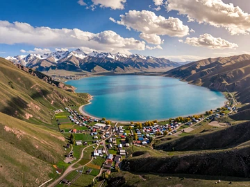 Stunning aerial view of Issyk-Kul lake surrounded by snow-capped Tien Shan mountains in Kyrgyzstan, symbolizing romantic natural beauty of Kyrgyz dating destinations